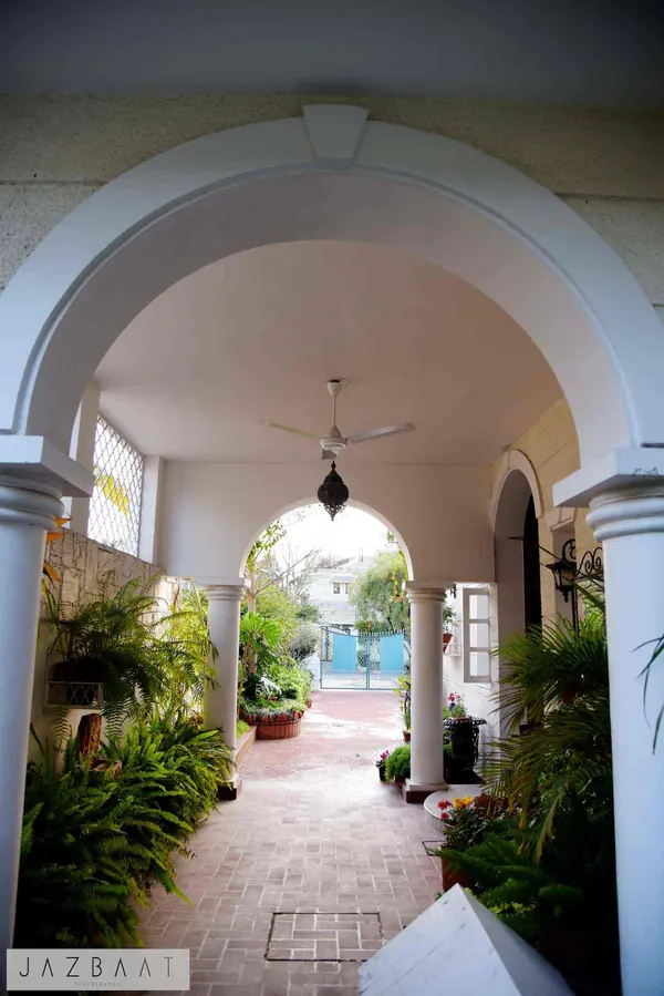 Arcadia: arched veranda framing a brick-paved garden walk