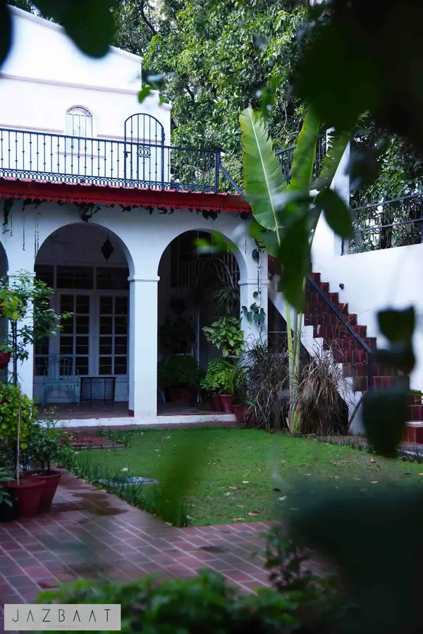 Arcadia: arched veranda and outdoor staircase beside the lawn courtyard