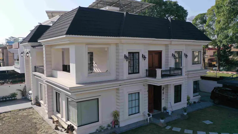 Archmere: aerial view of the white residence with a charcoal tiled roof, garden and boundary wall
