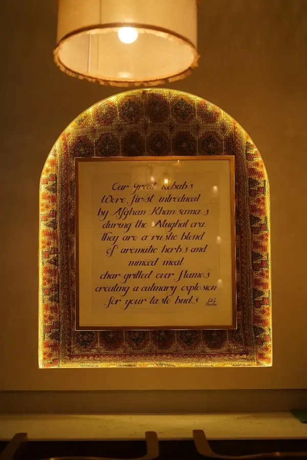 Basha Kabob, Sector 68, Mohali: backlit arched wall niche framing a hand-lettered story of the restaurant