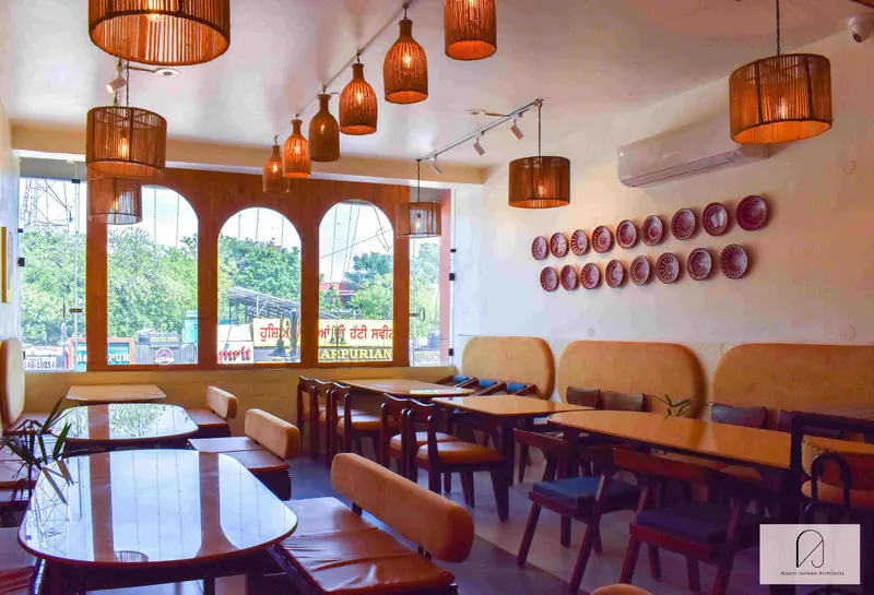 Chennai Maratha, Phase 5, Mohali: restaurant dining room with arched windows, timber tables and woven pendant lights