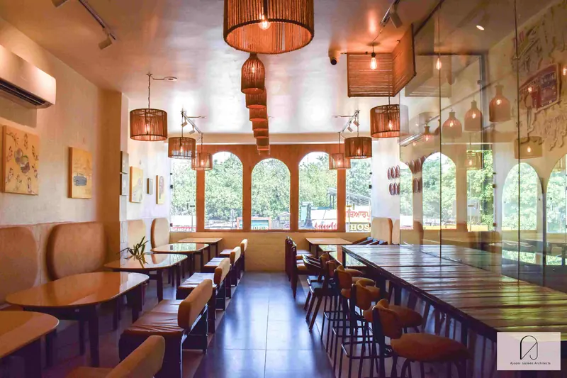 Chennai Maratha, Phase 5, Mohali: long dining room ending in a row of arched windows, with woven pendant lights