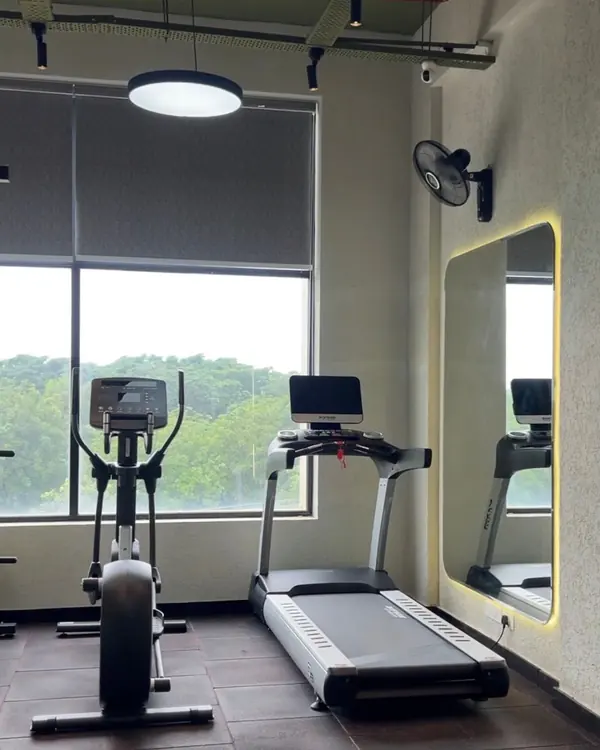 Fitness By Soma, Jubilee Junction, Mohali: cardio area by a full-height window, with a backlit arched mirror