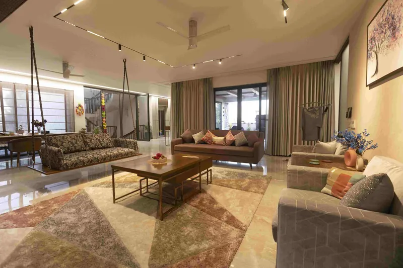 Interiors Contemporary: living room with a swing seat, layered rugs and full-height curtains